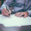 Man writing on paper at a desk